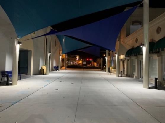 Night photo looking through a courtyard with blue shades overhead.